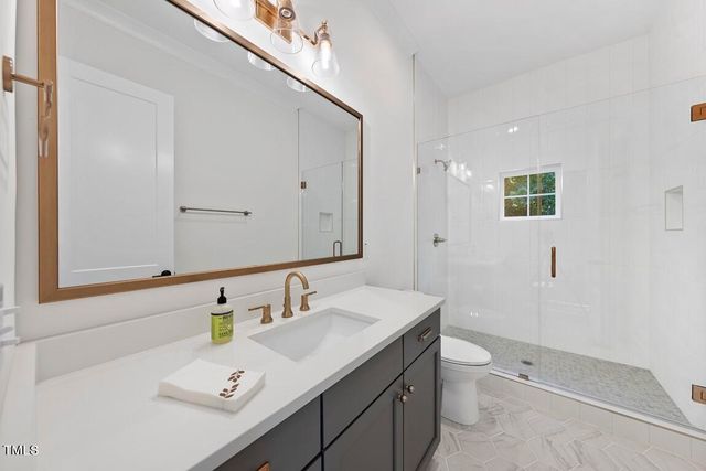 a bathroom with a sink a toilet and mirror