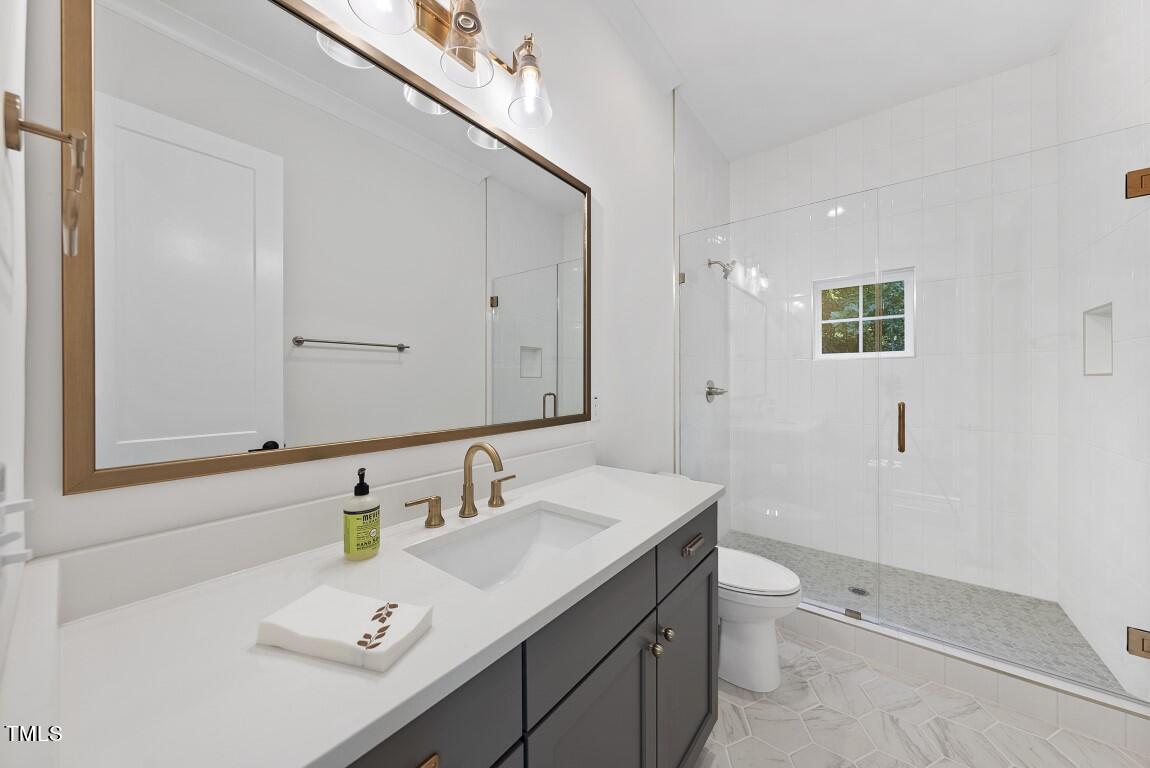 13541 Old Creedmoor Road Wake Forest, NC 27587 - Photo 26 of 41 a bathroom with a sink a toilet and mirror