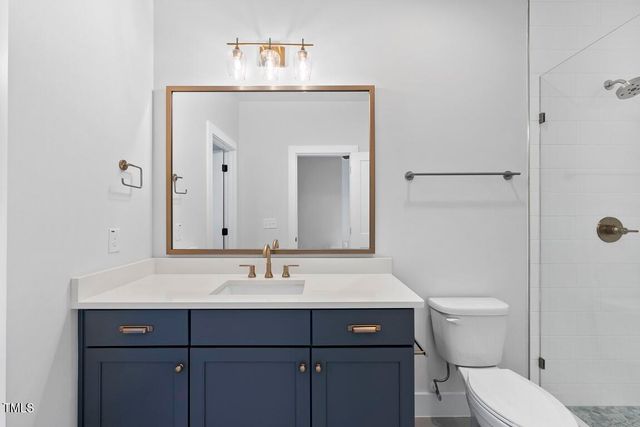 a bathroom with a sink a toilet and large mirror