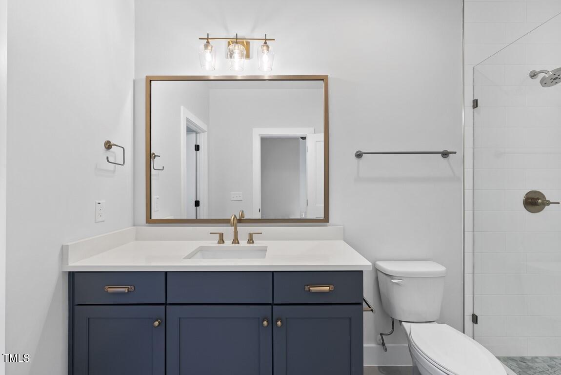 13541 Old Creedmoor Road Wake Forest, NC 27587 - Photo 27 of 41 a bathroom with a sink a toilet and large mirror