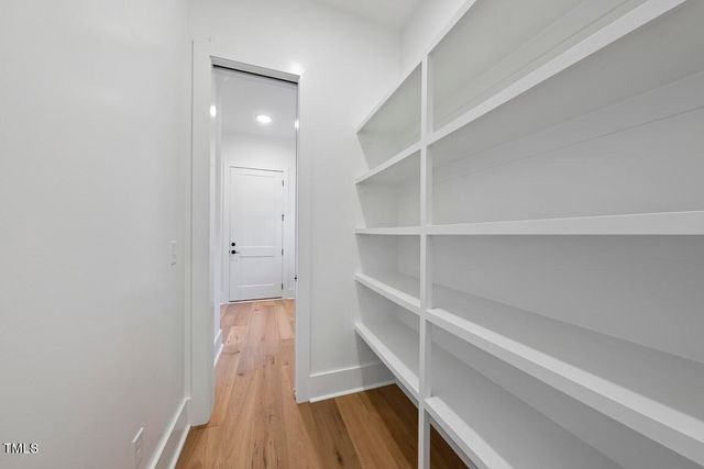 a view of a hallway with wooden floor and closet
