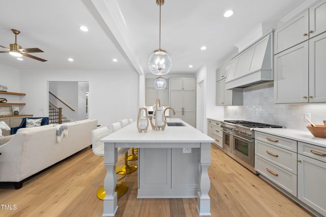 a kitchen with kitchen island a sink stainless steel appliances and wooden floor