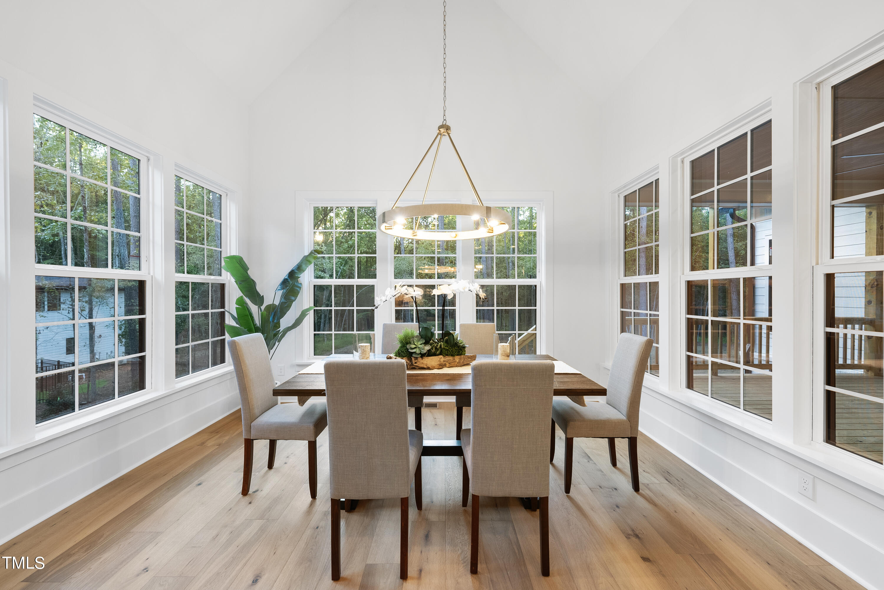 13541 Old Creedmoor Road Wake Forest, NC 27587 - Photo 7 of 41 a view of a dining room with furniture large windows and wooden floor