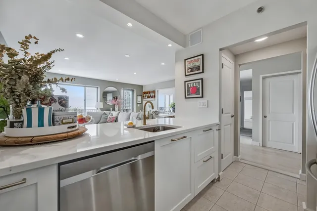 a kitchen with stainless steel appliances a sink a counter top space cabinets and a potted plant