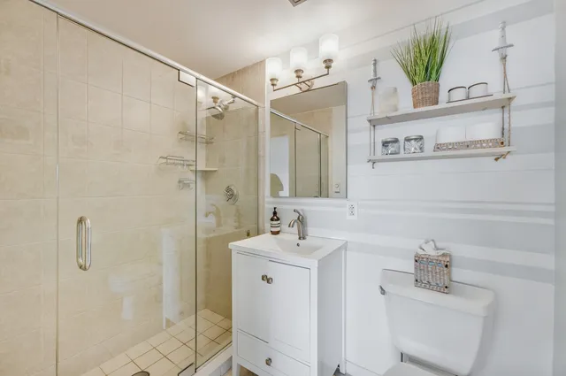 a spacious bedroom with a bed and a chandelier