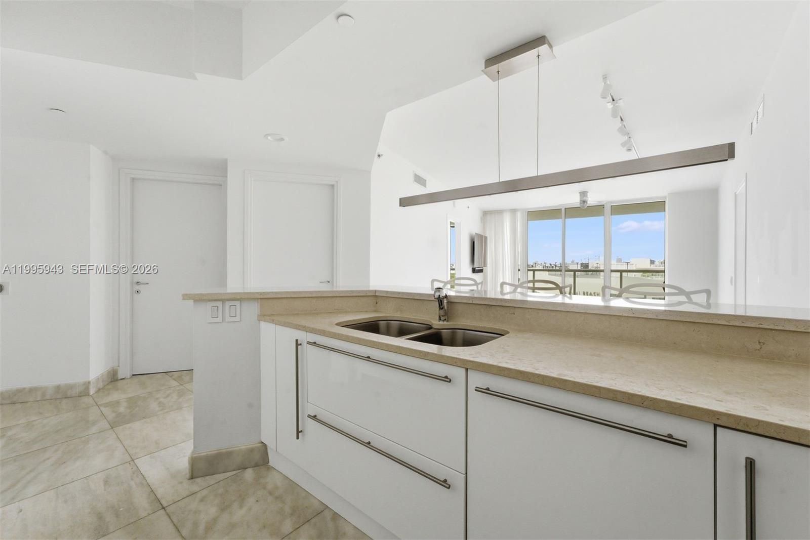 450 Alton Road, Unit 910 Miami Beach, FL 33139 - Photo 21 of 59 a kitchen with a sink and cabinets