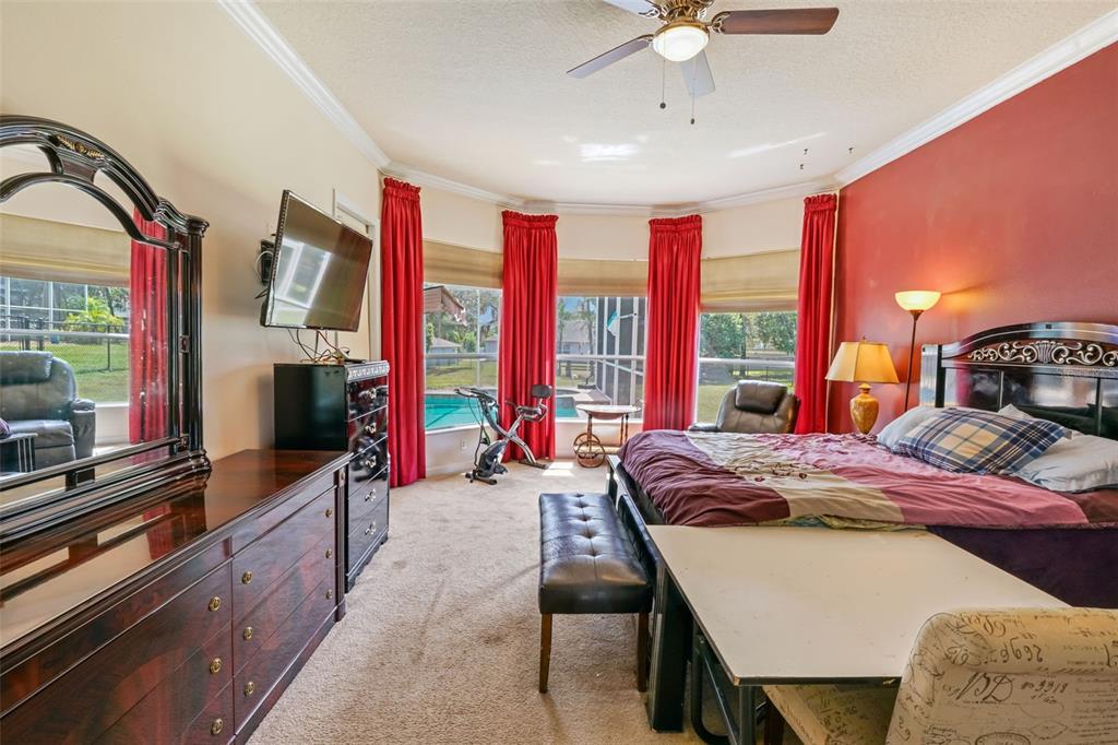 3362 Cedar Crest Loop Spring Hill, FL 34609 - Photo 14 of 57 a bedroom with a bed and large windows