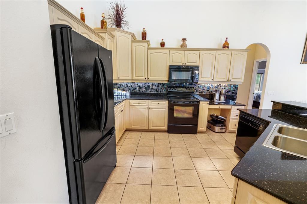 3362 Cedar Crest Loop Spring Hill, FL 34609 - Photo 3 of 57 a kitchen with stainless steel appliances granite countertop a refrigerator a stove and a sink