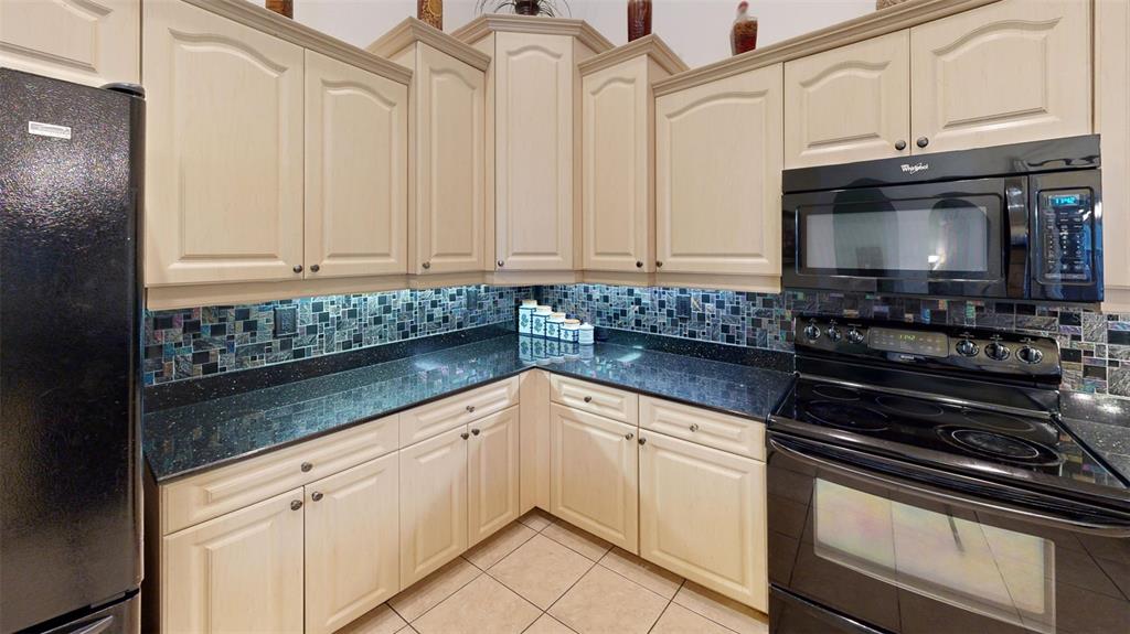 3362 Cedar Crest Loop Spring Hill, FL 34609 - Photo 5 of 57 a kitchen with stainless steel appliances granite countertop a sink stove and microwave
