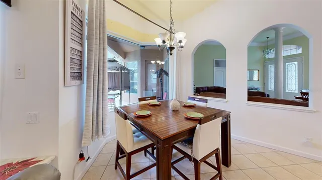 a living room with furniture a chandelier and a dining table