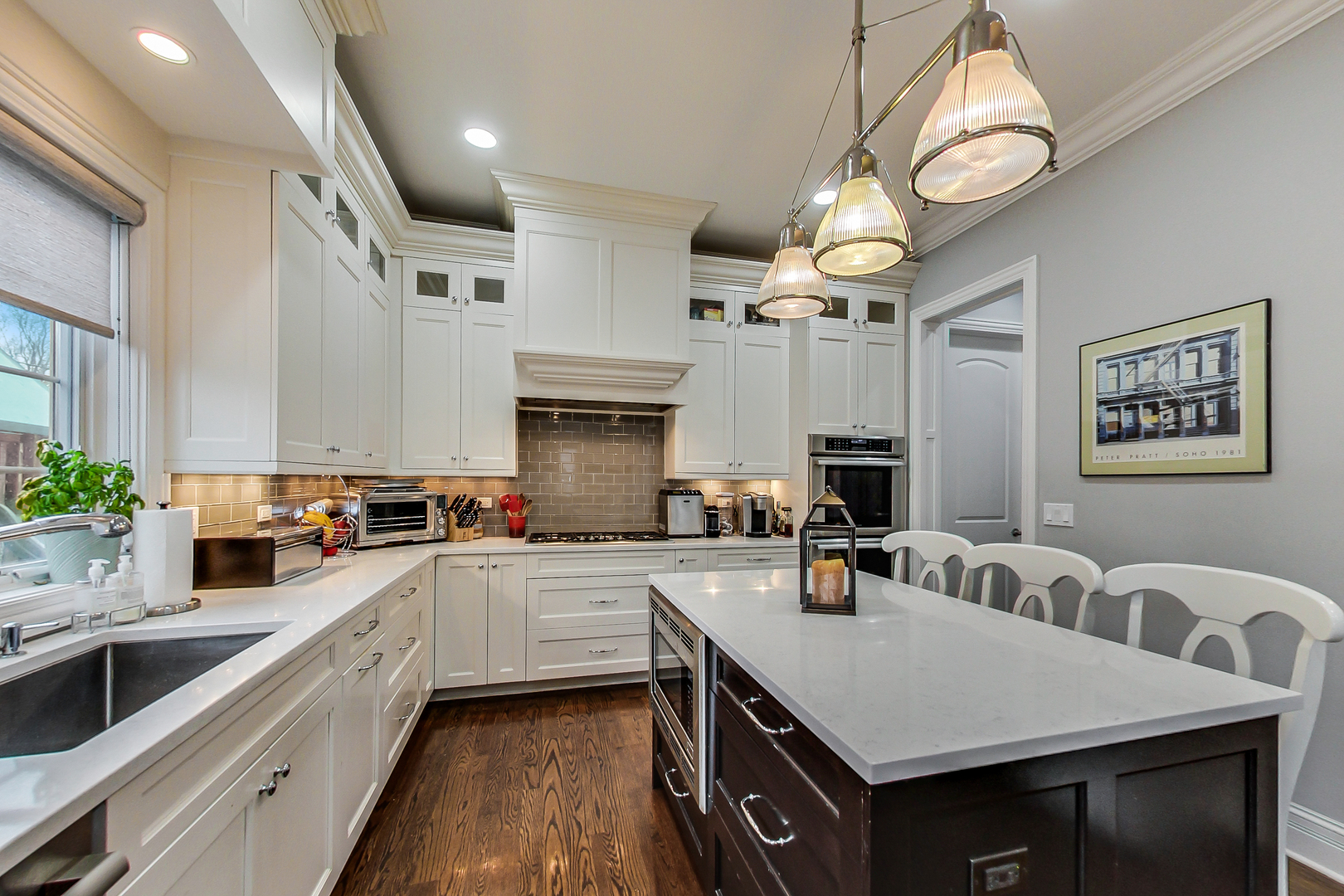 1049 Greentree Avenue Deerfield, IL 60015 - Photo 8 of 37 a kitchen with a sink dishwasher a stove top oven a dining table and chairs with wooden floor