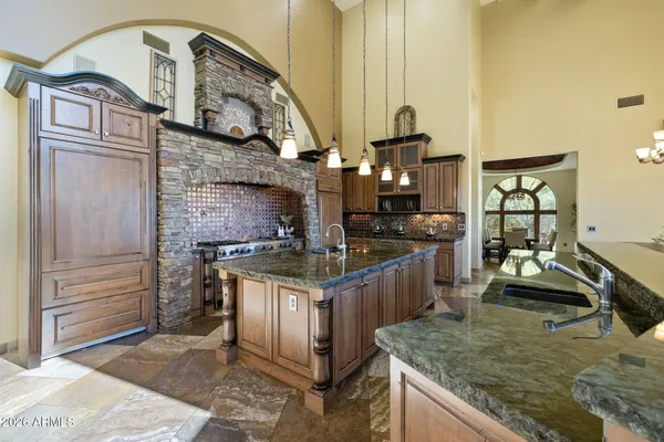 a bedroom with a large bed a chandelier with dresser and mirror
