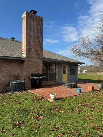 a view of a house with backyard sitting area and garden