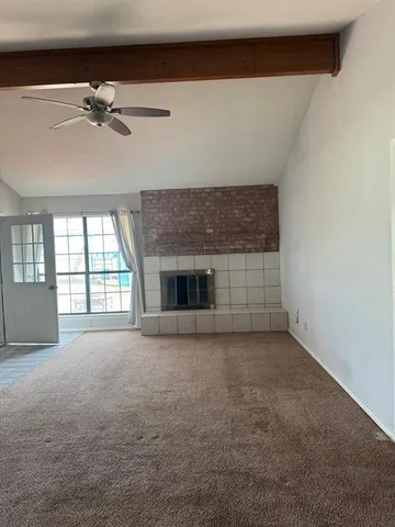 an empty room with a fireplace and windows