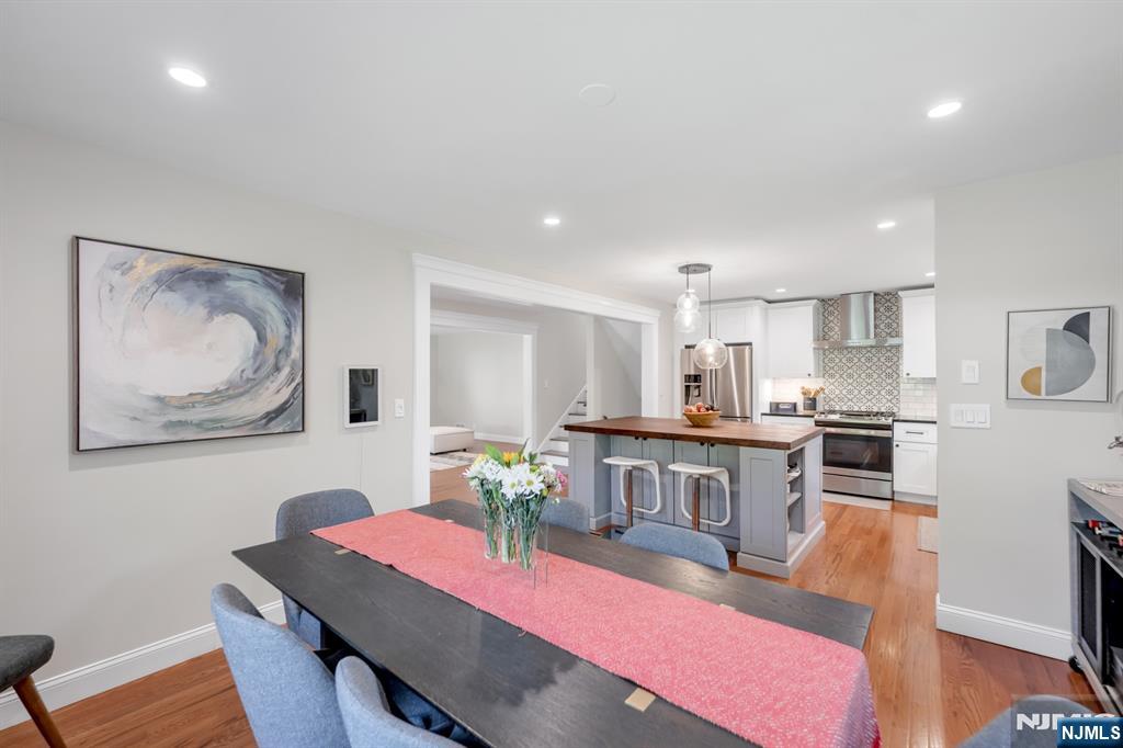433 Piermont Road Cresskill, NJ 07626 - Photo 9 of 49 a kitchen with stainless steel appliances kitchen island granite countertop a dining table chairs sink and cabinets