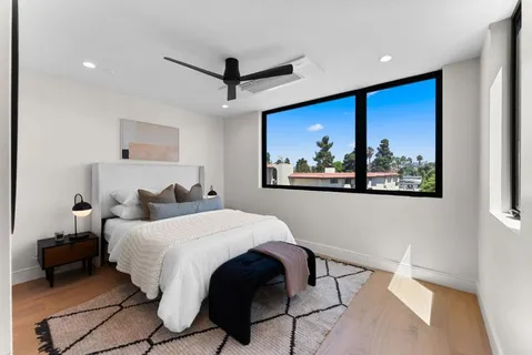 a bedroom with a large bed and a painting on the wall