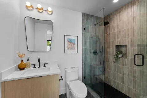 a bathroom with a sink a toilet and shower