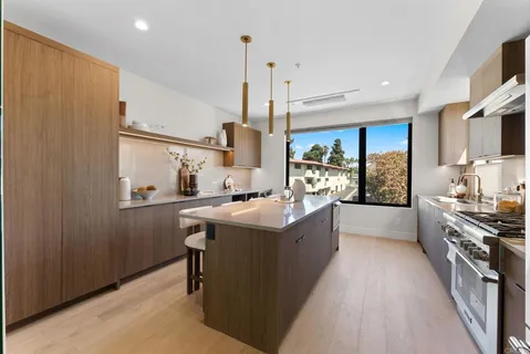 a kitchen with kitchen island granite countertop a sink a counter top space stainless steel appliances and cabinets
