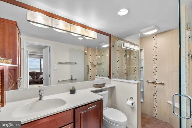 a bathroom with a sink a toilet a mirror and shower
