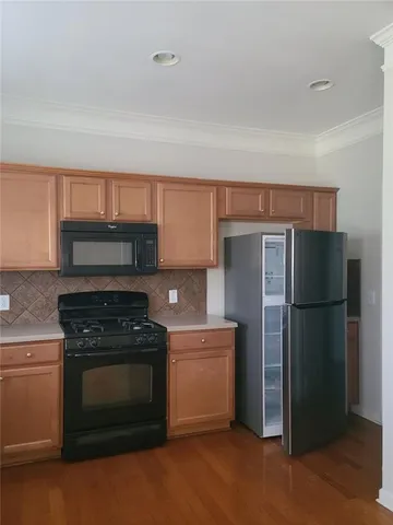 a kitchen with stainless steel appliances granite countertop a stove a sink and a refrigerator
