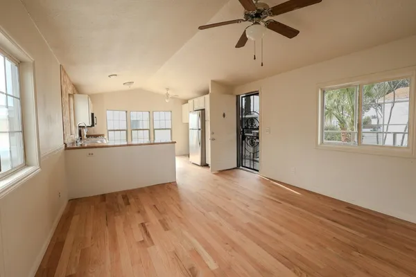 a view of a big room with wooden floor and windows