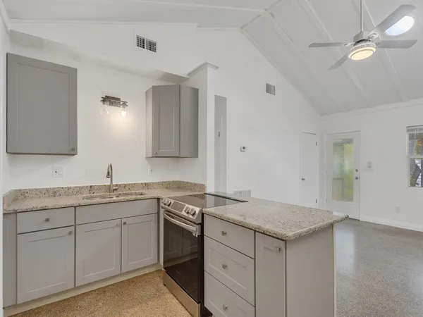 an empty room with a window and a ceiling fan