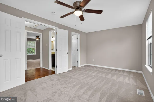wooden floor in an empty room with a chandelier fan