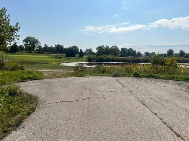 an aerial view of a golf course with a lake view