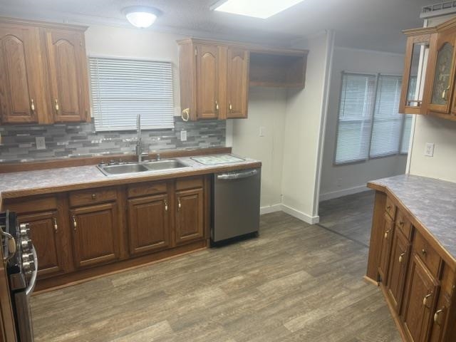 1100 Pine Top Road Toone, TN 38381 - Photo 6 of 40 Kitchen featuring wood-finish flooring, wood cabinetry with gold-tone hardware, a stainless steel double sink, a gray mosaic tile backsplash, and a built-in stainless steel dishwasher