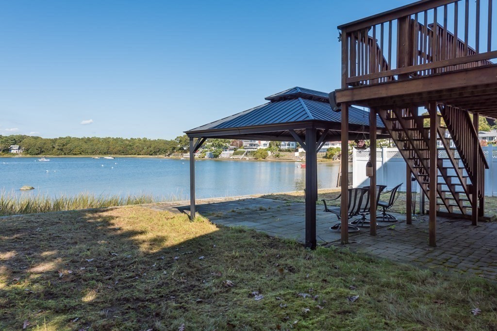 22 Cove Street Wareham, MA 02558 - Photo 12 of 35 a backyard of a house with table and chairs under an umbrella