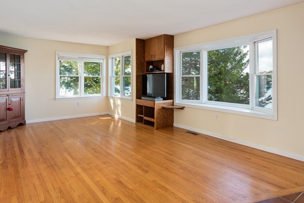 22 Cove Street Wareham, MA 02558 - Photo 13 of 35 a view of an empty room with a window and wooden floor