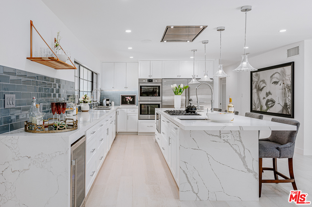 1075 Moraga Drive Los Angeles, CA 90049 - Photo 2 of 24 a kitchen with stainless steel appliances kitchen island granite countertop a sink and cabinets