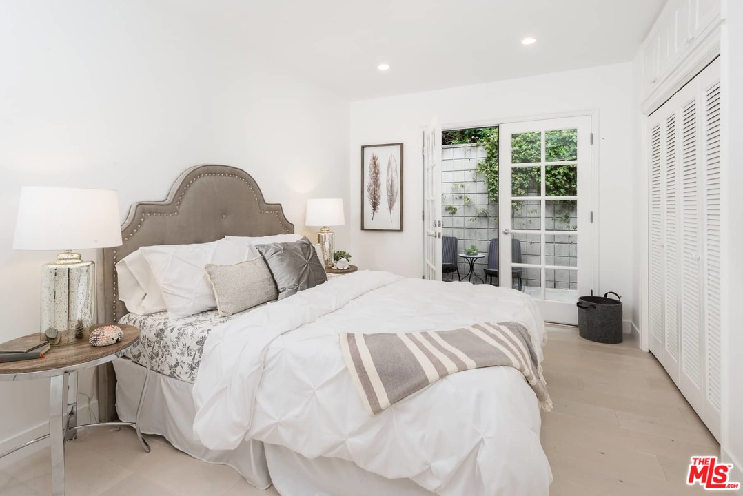 1075 Moraga Drive Los Angeles, CA 90049 - Photo 17 of 24 a large bed sitting in a bedroom next to a window