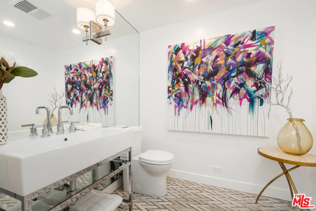 1075 Moraga Drive Los Angeles, CA 90049 - Photo 18 of 24 a bathroom with a sink mirror and vanity