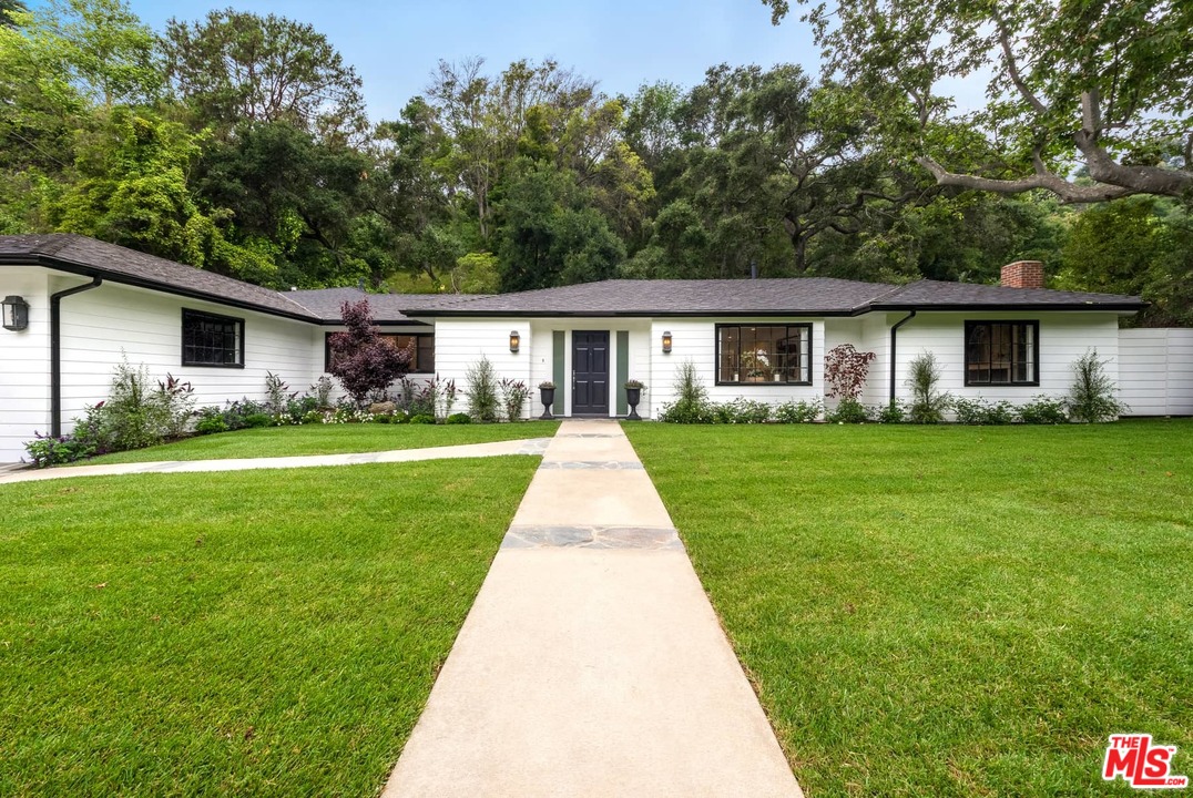 1075 Moraga Drive Los Angeles, CA 90049 - Photo 19 of 24 a front view of house with yard and green space