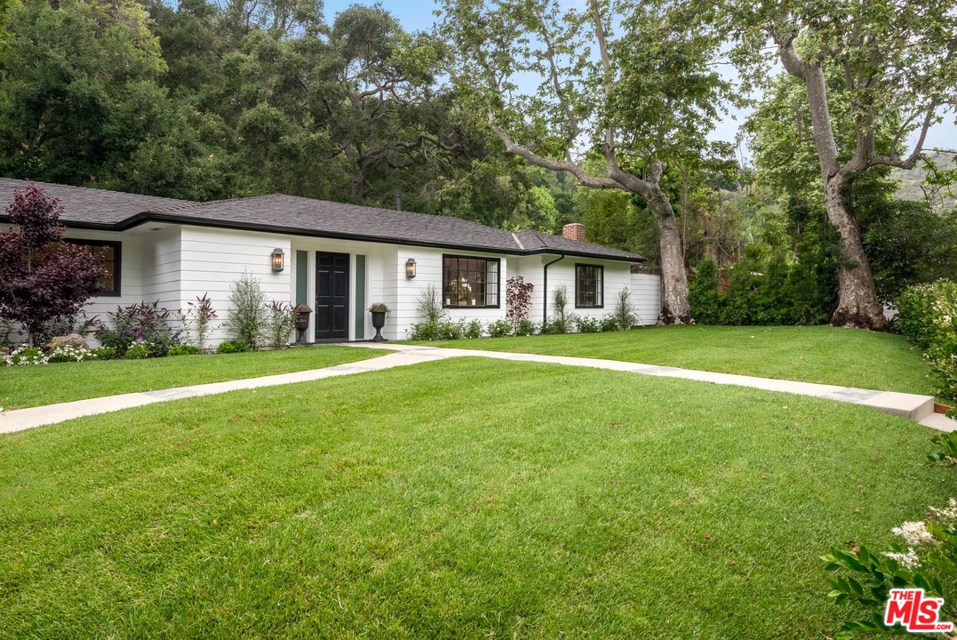 1075 Moraga Drive Los Angeles, CA 90049 - Photo 20 of 24 a front view of house with yard and green space