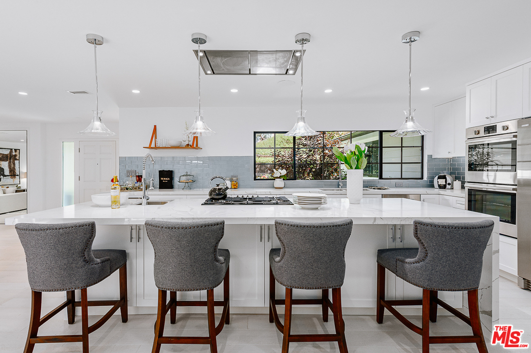 1075 Moraga Drive Los Angeles, CA 90049 - Photo 4 of 24 a kitchen with a sink and chairs
