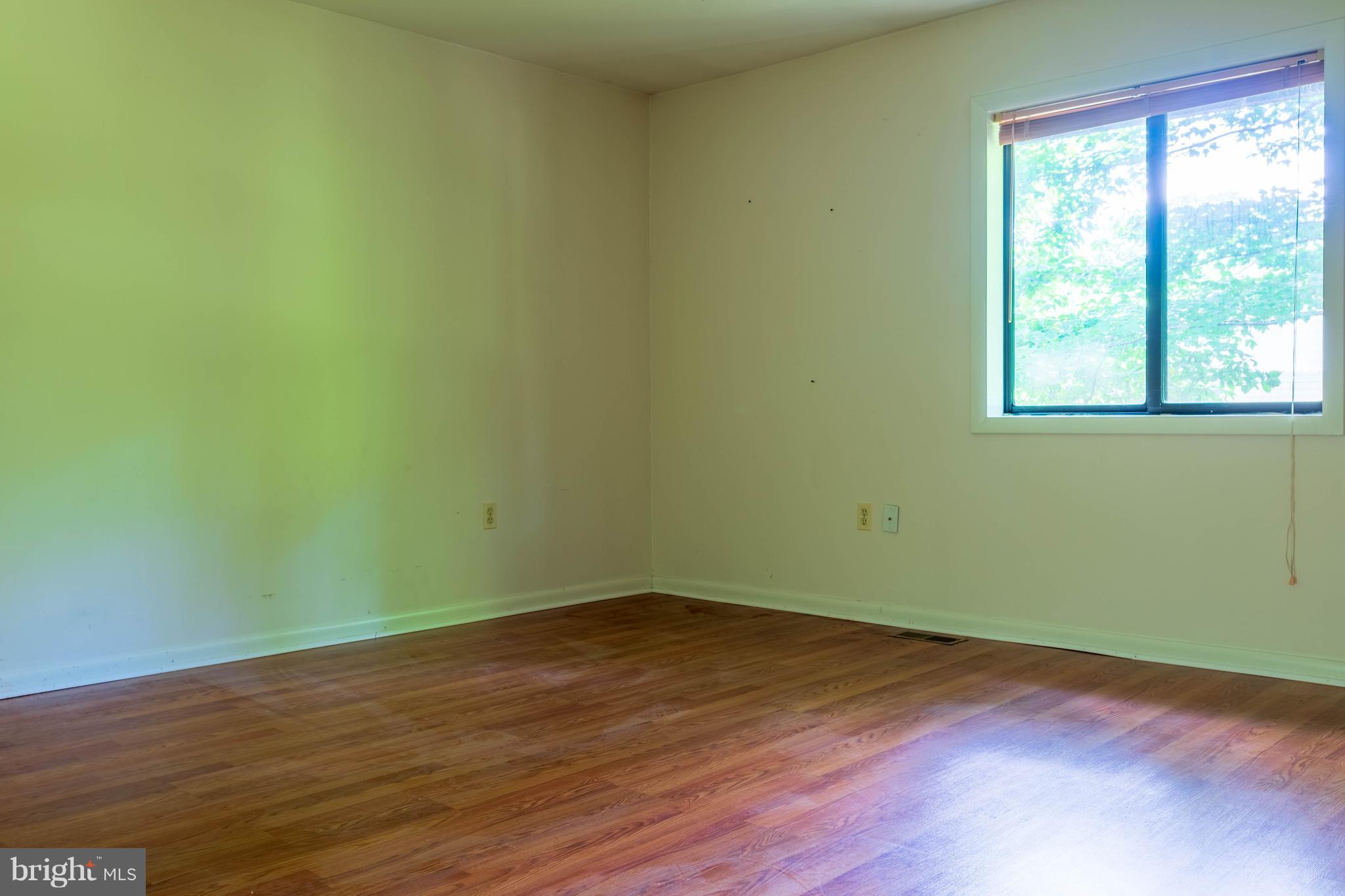 11227 Rawhide Road Lusby, MD 20657 - Photo 11 of 30 an empty room with wooden floor and windows