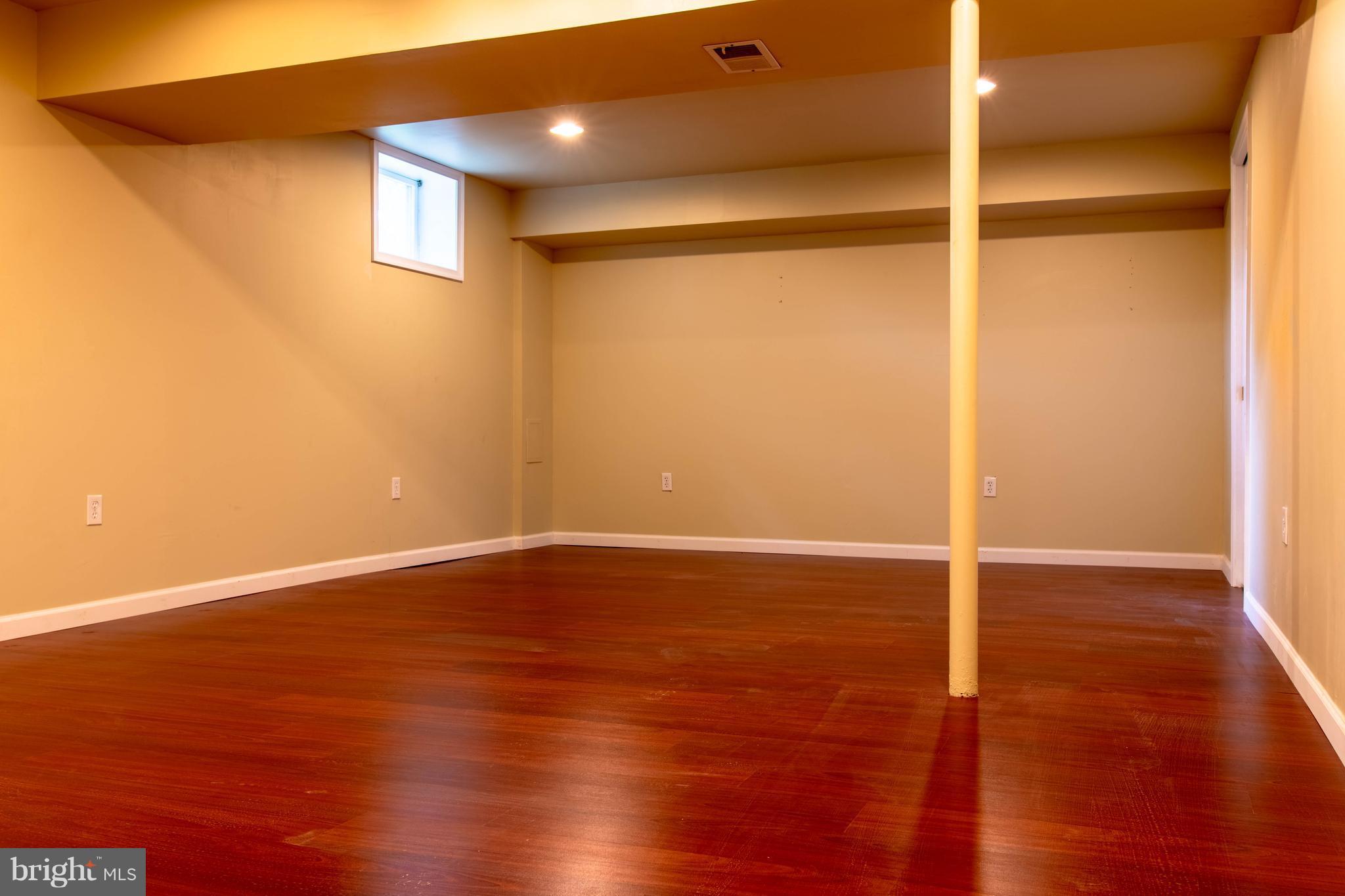 11227 Rawhide Road Lusby, MD 20657 - Photo 16 of 30 a view of an empty room with wooden floor and a window