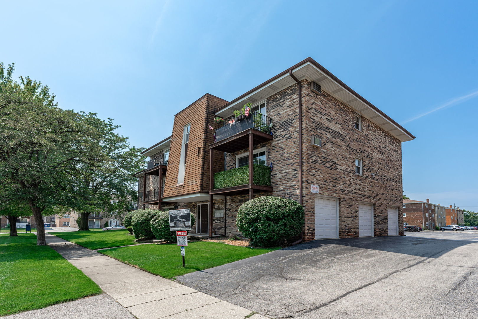7100 99th Street, Unit 204 Chicago Ridge, IL 60415 - Photo 16 of 18 a view of a brick house next to a yard with big trees