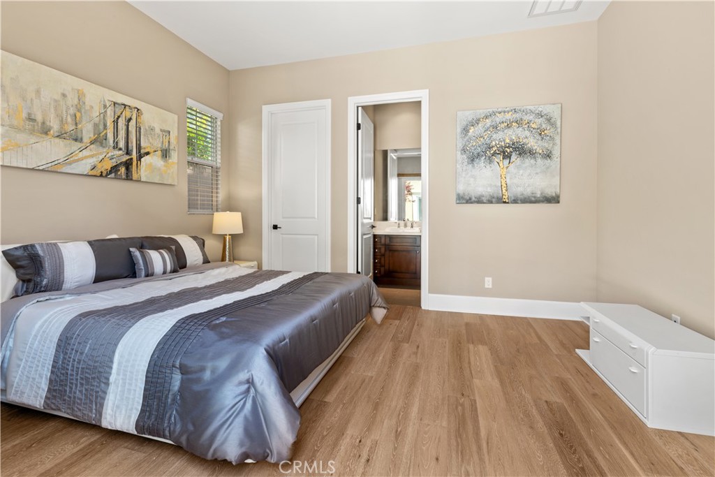 57 Harrison Irvine, CA 92618 - Photo 27 of 28 a spacious bedroom with a bed and painting on the wall