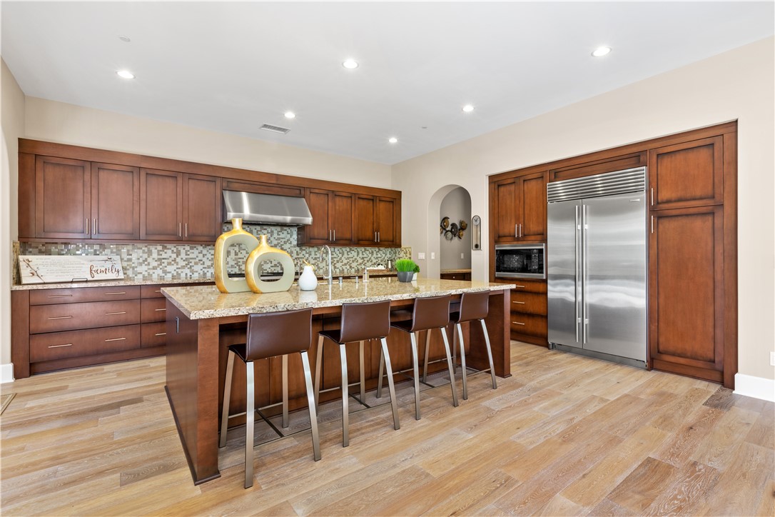 57 Harrison Irvine, CA 92618 - Photo 5 of 28 a kitchen with stainless steel appliances granite countertop a center island stools and a refrigerator stove a oven with wooden floor