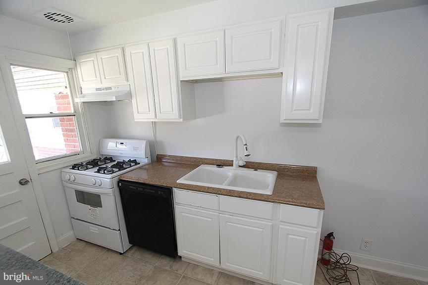 7436 Manchester Road Dundalk, MD 21222 - Photo 14 of 16 a kitchen with a sink stove and cabinets
