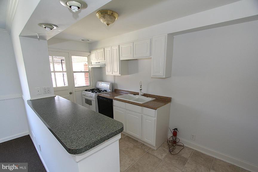7436 Manchester Road Dundalk, MD 21222 - Photo 4 of 16 a kitchen with granite countertop a sink a stove and refrigerator