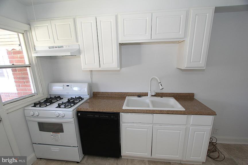 7436 Manchester Road Dundalk, MD 21222 - Photo 5 of 16 a kitchen with white cabinets and white appliances