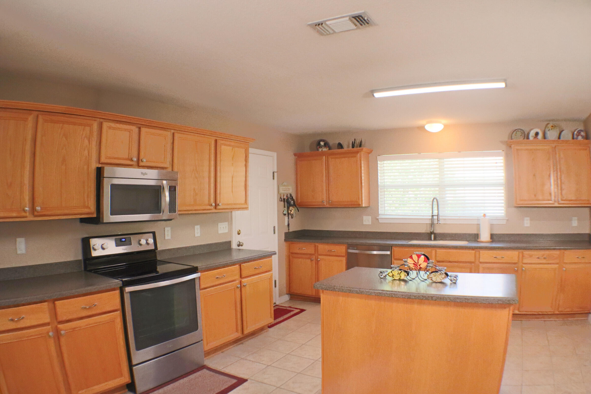 564 East Shipwreck Road Santa Rosa Beach, FL 32459 - Photo 11 of 38 a kitchen with stainless steel appliances granite countertop a stove a sink and a microwave