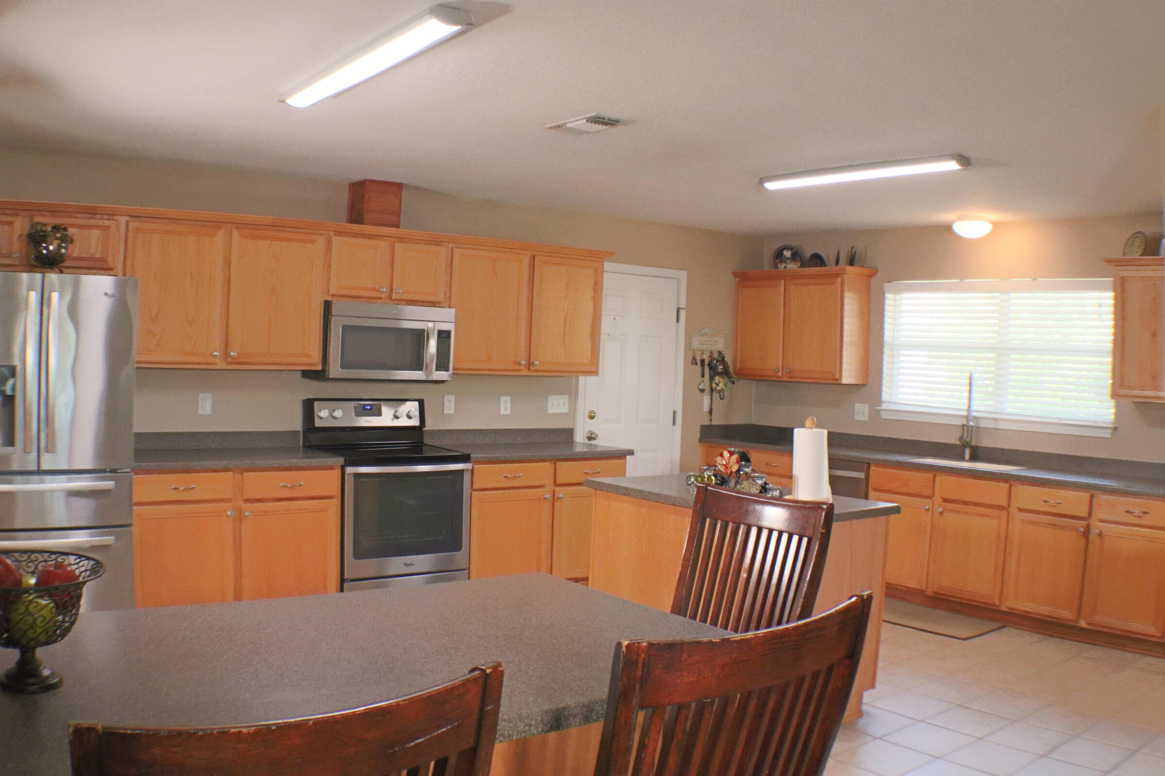 564 East Shipwreck Road Santa Rosa Beach, FL 32459 - Photo 10 of 38 a kitchen with stainless steel appliances granite countertop a refrigerator a stove top oven a sink dishwasher and white cabinets with wooden floor