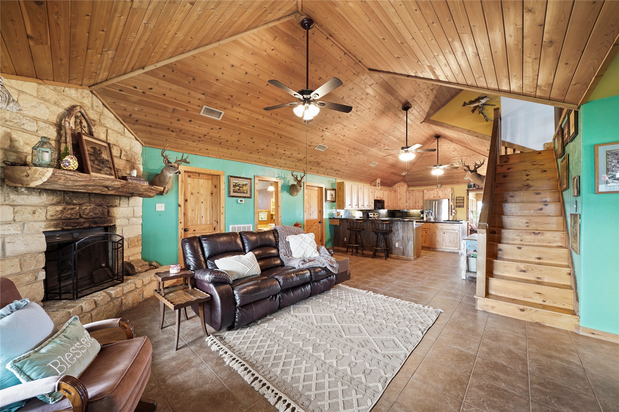 6710 Boothline Road Richmond, TX 77469 - Photo 9 of 43 This cozy living space features a rustic stone fireplace, high ceilings, and an open-plan design.