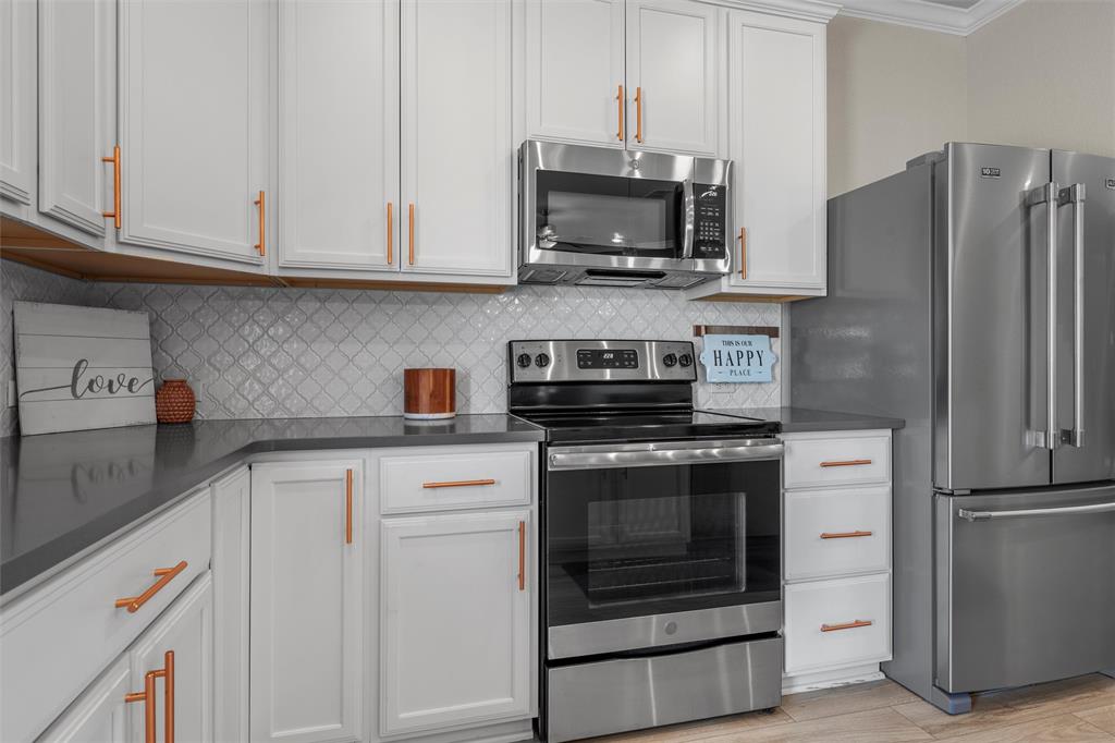 11308 Gulch Drive Lorena, TX 76655 - Photo 7 of 40 a kitchen with stainless steel appliances granite countertop white cabinets a refrigerator and a stove a oven with white countertops