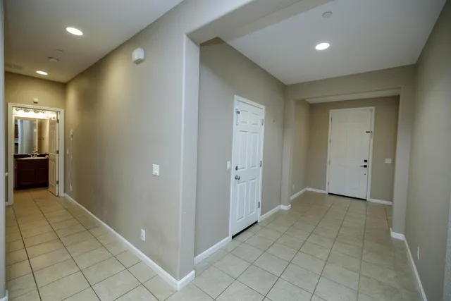 an empty room with a fan & a ceiling fan